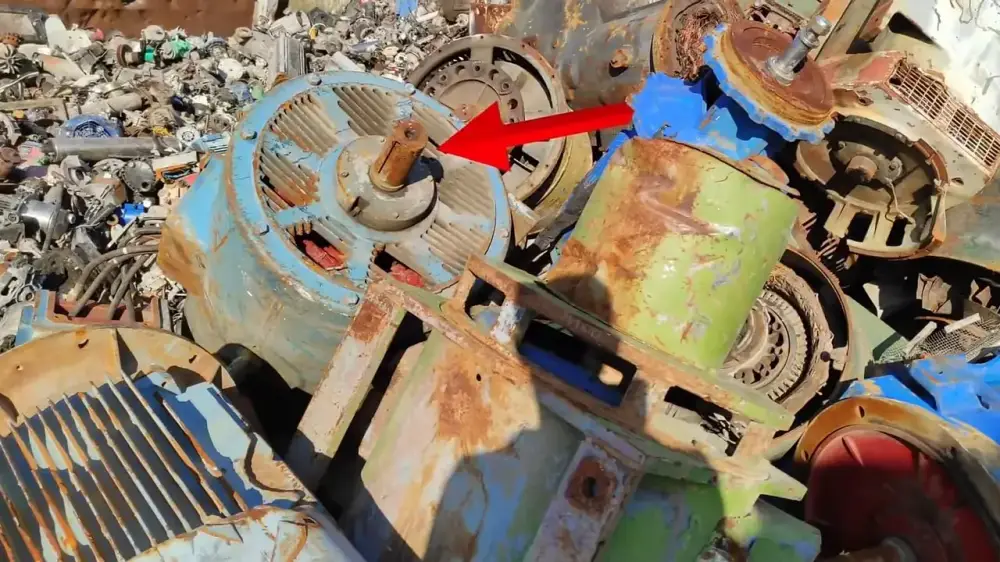 Rusty industrial electric motor lying in a scrapyard with 500 dollar text