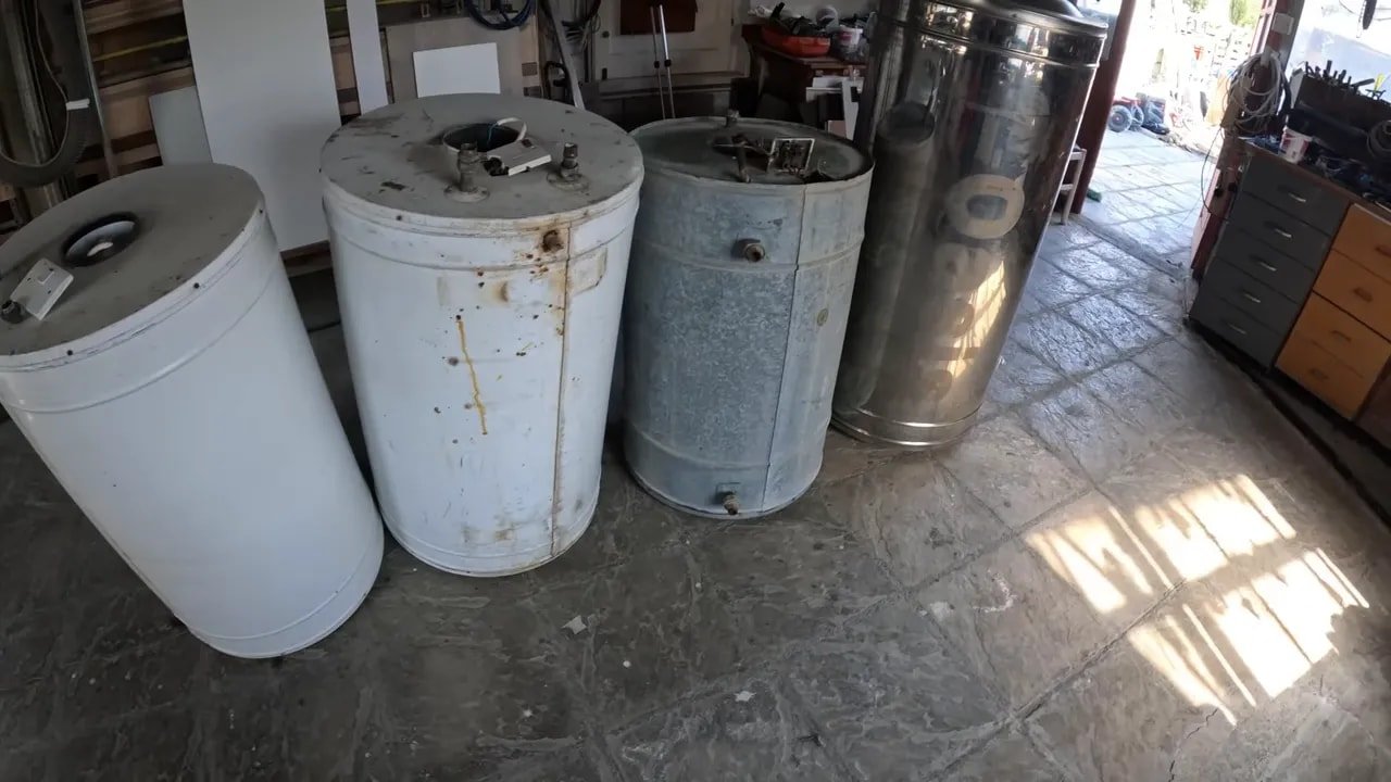 Four old water heaters standing in a workshop with a 500 dollar graphic
