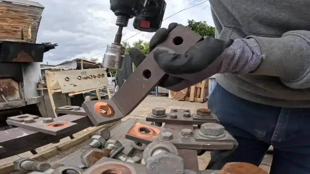 Copper bus bars, bolts, brackets and electrical supports arranged on a work surface