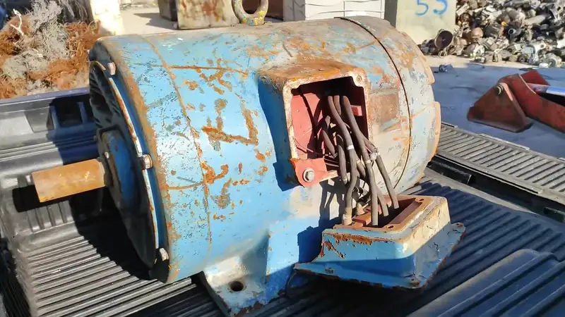 Rusty industrial electric motor lying in a scrapyard with 500 dollar text