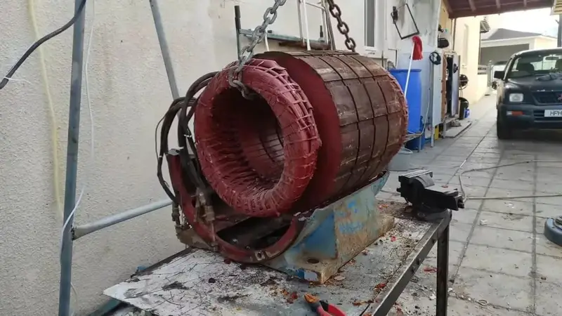 Open blue electric motor showing red stator windings and rusty shaft